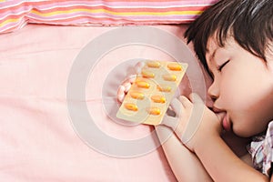 Little Asian Boy Sleep with Medicine panel in hand.