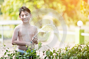 Little Asian boy watering the tree