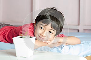 Little asian boy wating for new baby plant grow up