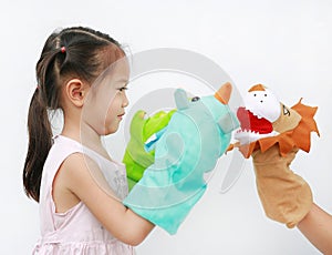 Little Asian child girl hands playing animal puppets with hand of her mother on white background. Educations concept photo