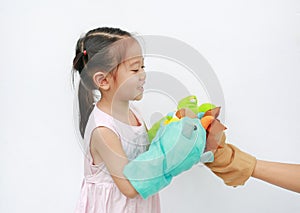 Little Asian child girl hands playing animal puppets with hand of her mother on white background. Educations concept photo