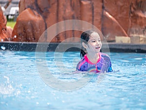 Little asian child girl play on the pool in summer