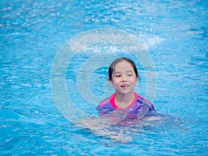 Little asian child girl play on the pool in summer