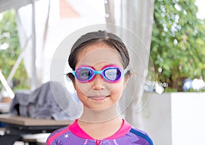 Little asian child girl wear goggles before play on the pool in summer