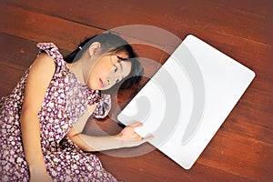 Little Asian child laying down on the wooden background with a b