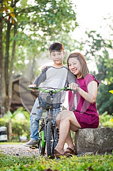 Little Asian child with mother practice to riding a bicycle