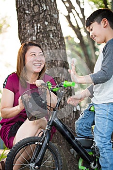 Little Asian child with mother practice to riding a bicycle