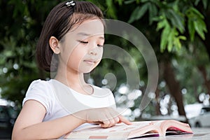 Little Asian child reading a book