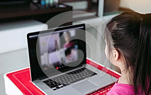 Little asian girl attending to online e-learning platform class from home while school has been closed during coronavirus outbreak