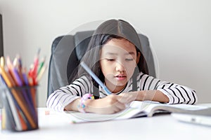 Little Asian girl doing homework for self learning and education concept select focus