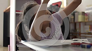 Little asian girl doing homework on study desk with her mother at home.