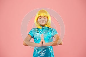 Little asian girl hand praying. small girl traditional eastern clothes. asian girl yellow hair wig. arigato. happy kid photo