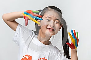 Little Asian girl with hands painted in colorful paints