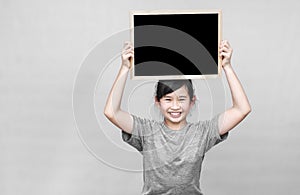 Little asian girl holding blackboard.
