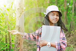 A little Asian girl holding tablet at the tropical farm, Little famer smile with happiness