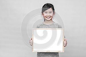 Little asian girl holding whiteboard