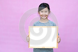 Little asian girl holding whiteboard.