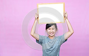 Little asian girl holding whiteboard.