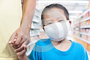 Little Asian girl kids wearing medical protective mask holds Daddy`s hand