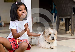 Little Asian girl playing with her dog at home Selective focus