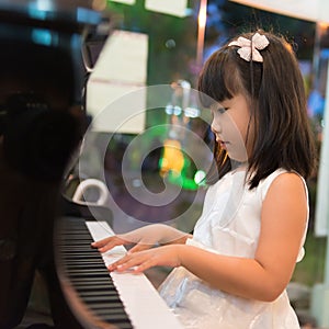 Little Asian girl playing piano