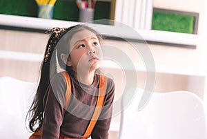 Little Asian girl portrait is wondering thinking dreaming