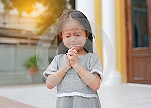 Little asian girl stance praying in the garden at the morning. Little kid girl hand praying, Hands folded in prayer concept for