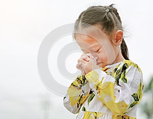 Little asian girl stance praying in the garden at the morning. Little kid girl hand praying, Hands folded in prayer concept for