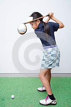 Little asian girl takine golf club training