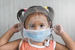 Little asian girl wearing a surgical mask.