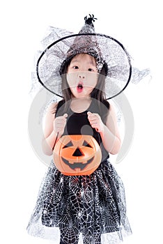 Little asian girl wearing witch costume for Halloween holding pu