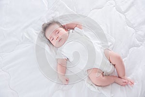 Infant sleeping on white bed in the morning