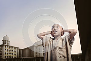 Little asian muslim boy wearing cap praying