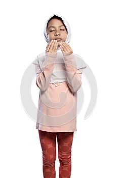 Little asian muslim girl wearing veil praying to god