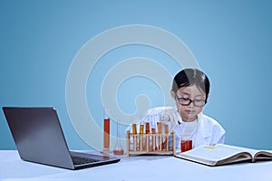 Little asian scientist doing experiment