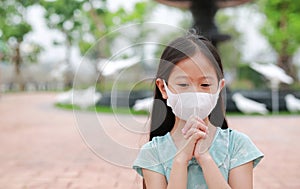 Little Asian young girl child wear face mask pray gesture for stop covid-19 during coronavirus outbreak in Thailand