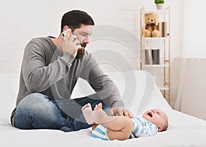 Little babby suffering from colic, dad calling to doctor photo