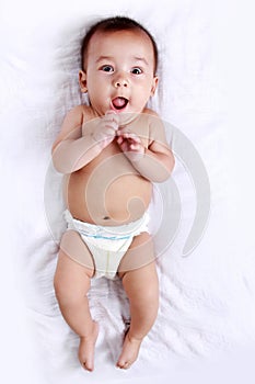 Little baby with adorable expressions lying on bed