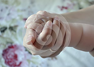 Little baby arm in a female hand. Theme of motherhood and childhood, child protection