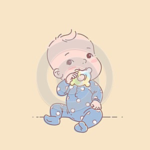 Little baby boy in blue pajamas sit, hold teething ring