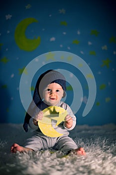 Little baby boy with cute teddy bear and moon on a blue star and