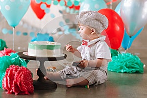 Little baby boy eating cake on his first birthday cakesmash party