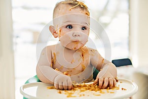 Little baby boy eating her dinner and making a mess