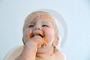 Little baby boy eating spaghetti bolognese. Cute kid making a mess