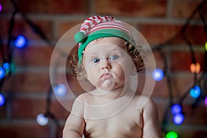 Little baby boy in elf hat with fairy lights