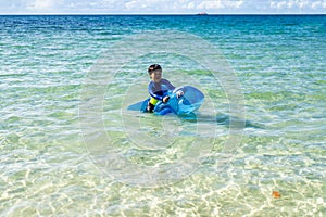 A Little baby boy with inflatable toy float playing in the water on summer vacation in a tropical resort. Kid with toy shark on a