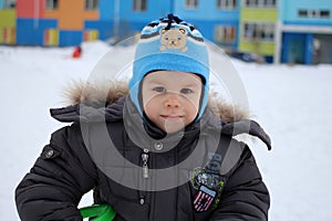 Little baby boy joyful walks in winter outside playing