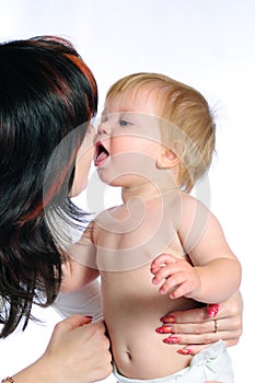 Little baby boy kissing mother