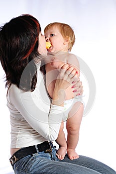 Little baby boy kissing mother