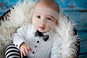 Little baby boy with knitted ladybug hat and pants in a basket